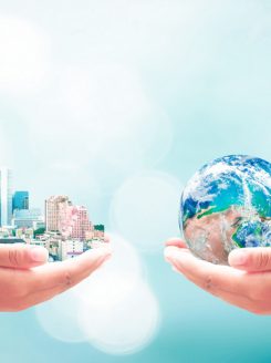 Two human hands holding earth global and big city on blurred blue nature background. Elements of this image furnished by NASA